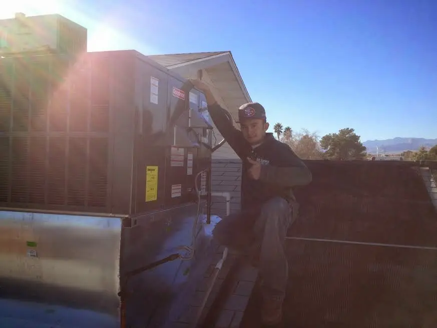 HVAC technician performing AC Tune-Up on a rooftop unit in North Alamo